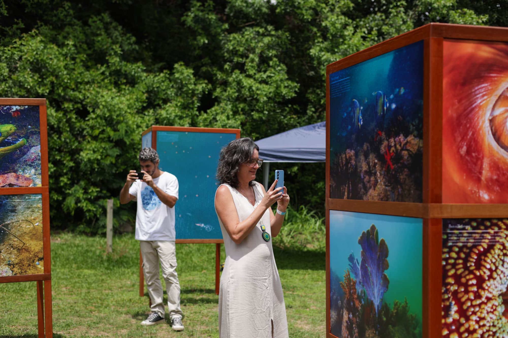 Exposição fotográfica do livro "Baía das Tartarugas" com totens mostrando imagens do livro