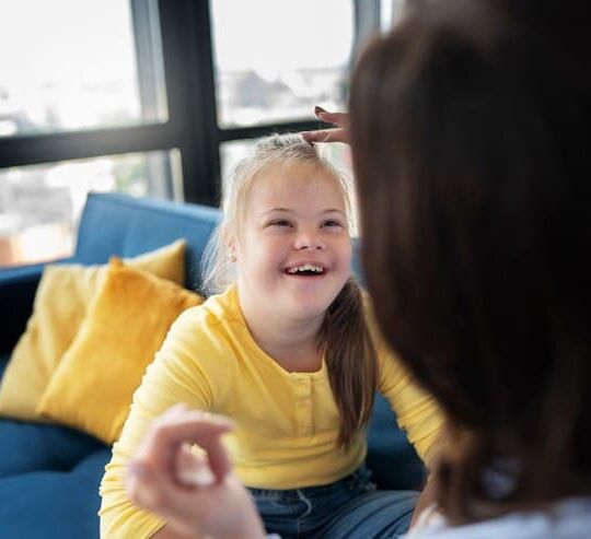 high-angle-smiley-girl-with-down-syndrome_23-2149632391.jpg