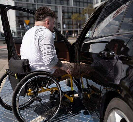 Homem em cadeira de rodas entrando no carro